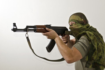 Man in scarf with gun against white background