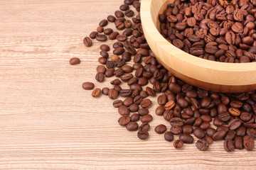 Plate with coffee beans on wooden table