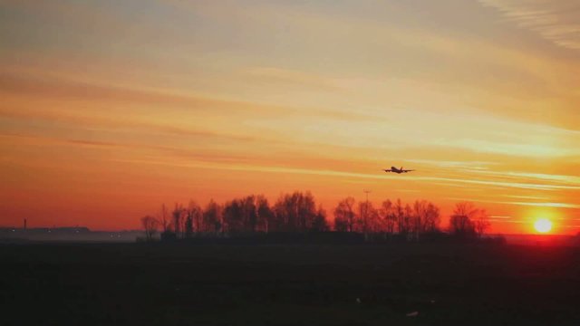 plane takes off from the airport. View of the sunrise.