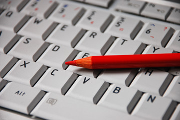 Red pencil on computer keyboard