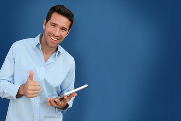 Attractive man with touchpad on blue background