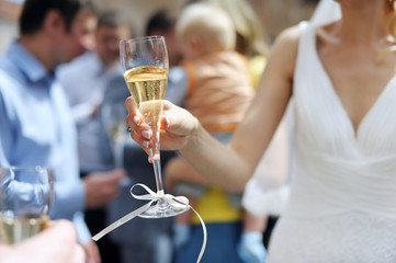 Bride is holding champagne glass after a wedding ceremony