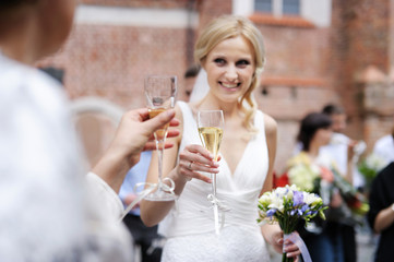 Bride is holding champagne glass after a wedding ceremony