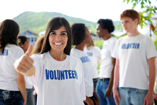 happy volunteer woman showing thumbs up sign