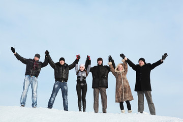 Six young people hold on hands and lift them upwards