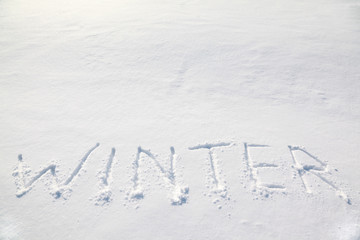 big words "winter" on white cold snow field
