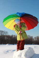 pensive girl holding colorful umbrella at outside in winter