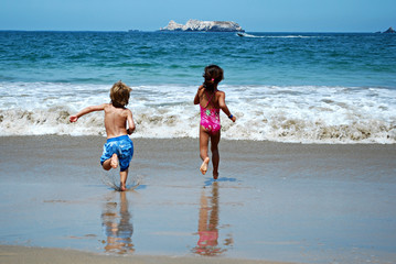 Boy and girl running on beach