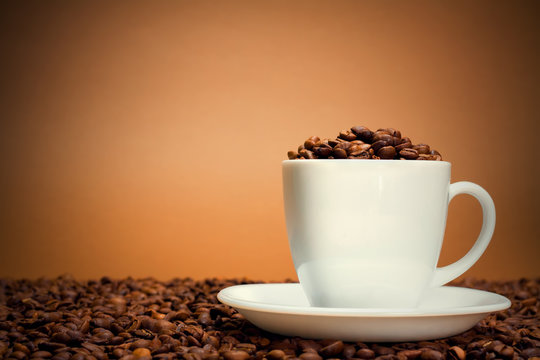White cup filled with coffee beans
