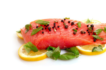 Red fish with pepper and green leaves isolated on white