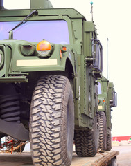 Crop of green military vehicles being transported