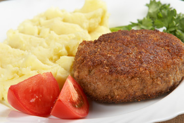 Cutlet with mashed potato and vegetables on white plate