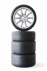 Isolated set of low profile summer tyres with one wheel on top