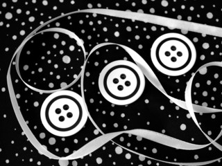 White buttons and ribbons on black polka dot