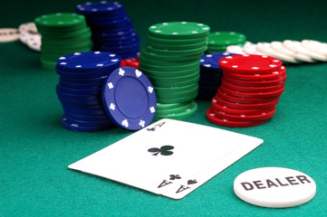 cards and stack of Poker chips and dealer button