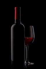 bottle with red wine and glass on a red gradient