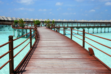 Fototapeta premium Maldives 美しい海の上のコテージへ続く桟橋の風景
