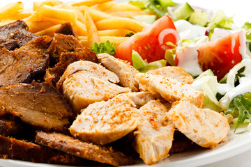 Grilled meat with French fries and vegetables