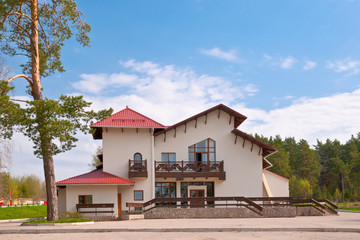 Obraz premium house with red roof against the backdrop of a pine forest