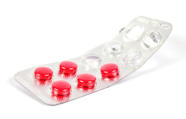 A used tabled with five red pills remaining inside isolated on w