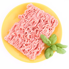 Raw minced meat on a plate decorated with basil
