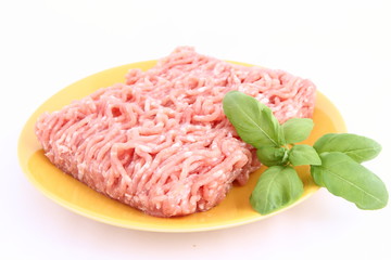 Raw minced meat on a plate decorated with basil