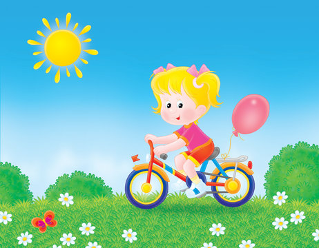 girl cycling through a field in summer day