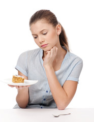 Pretty young woman eating cake. Isolated