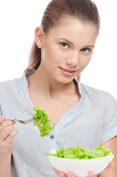 Pretty young woman eating lettuce salad. Isolated