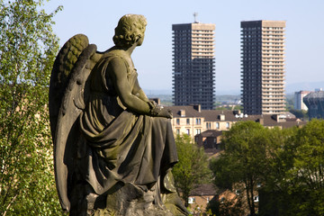 Urban angel contemplating high-rise tower blocks