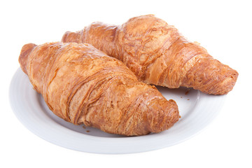 Two delicious croissants on a plate, isolated on white