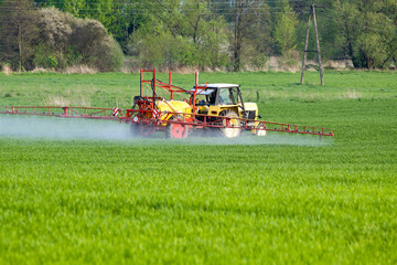 Tractor spraying a field on farm, agriculture