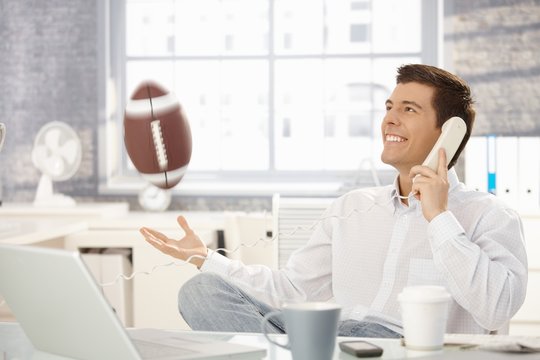 Businessman playing with football in office