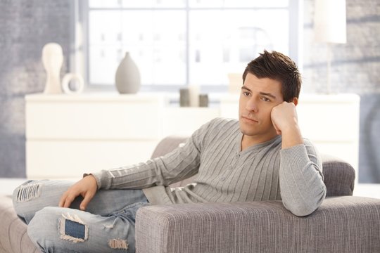 Young man daydreaming on sofa