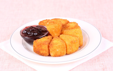 Fried cheese on a dish with cranberry jam
