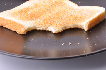pieces of toast on black dish isolated on white background.