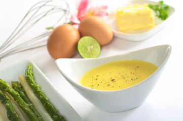 Hollandaise sauce with black pepper and asparagus on the side