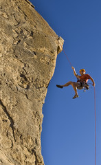 Rock climber rappelling.