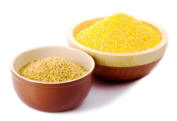 Hominy grits and wheat grits in wooden plates isolated on white