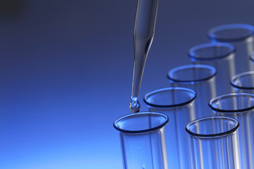test tube with dropper on blue background