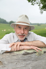 Fototapeta premium Farmer leaning on farmland fence