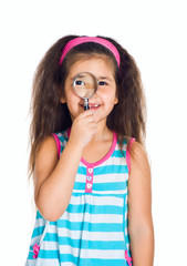 little girl looking through a magnifier