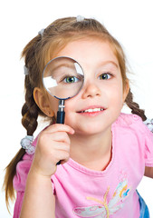 little girl looking through a magnifier