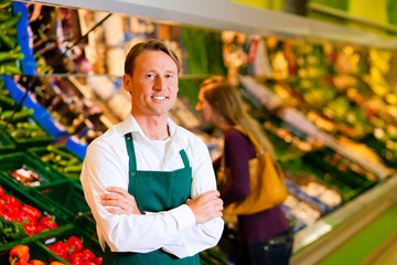 Fototapeta na wymiar Człowiek w supermarkecie jako sprzedawca