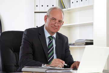 alter Businessmann mit Laptop