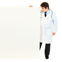 Full length portrait of doctor looking at blank billboard