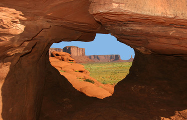 Monument Valley framed by opening in rock formation - Arizona