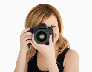 Blond-haired woman taking a photo with a camera