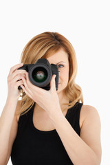Attractive blond-haired woman taking a photo with a camera