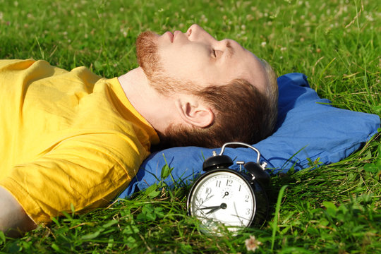 man white breard in yellow shirt sleeping on summer meadow near